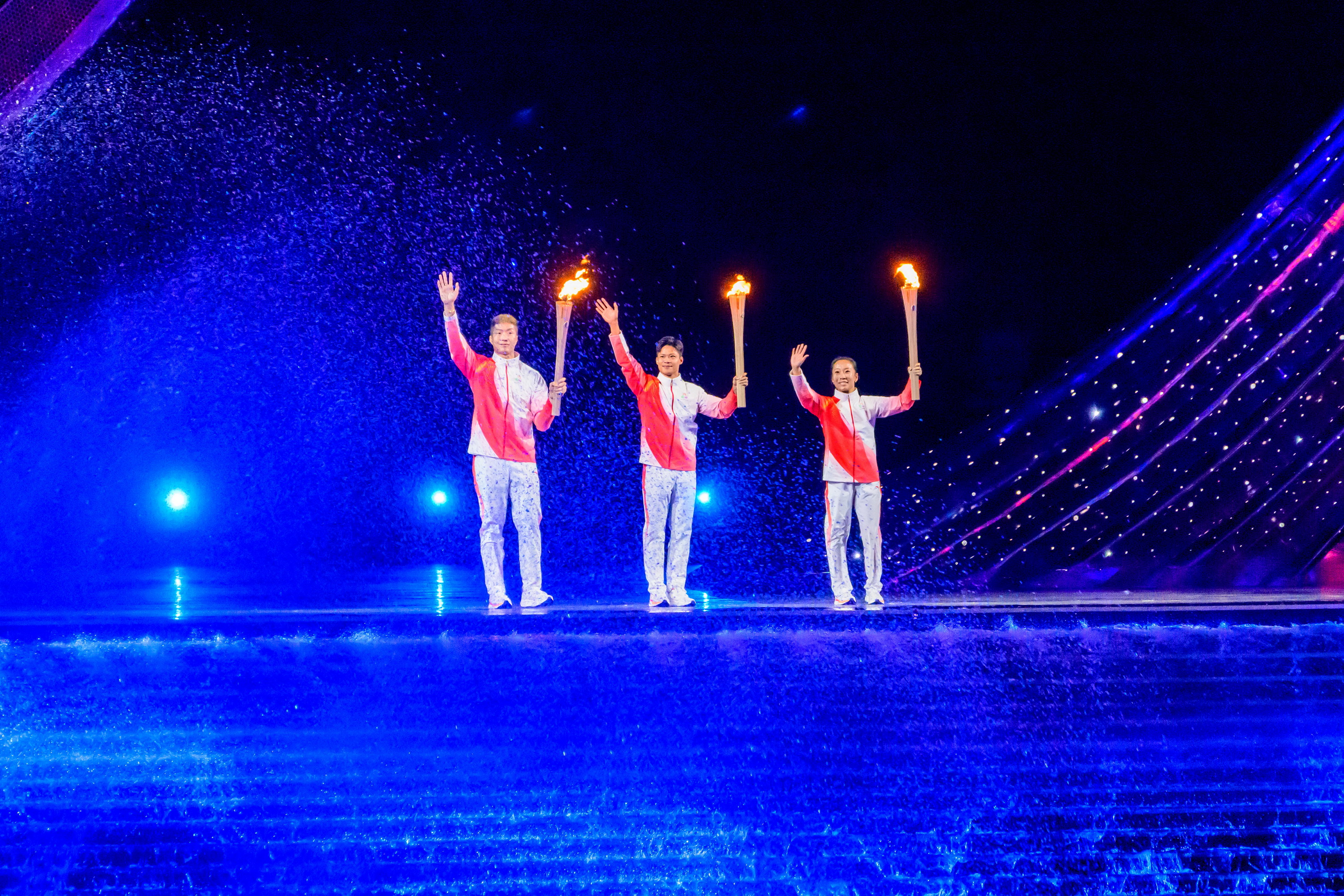 Cheung Ka-long (left) lights the cauldron on behalf of Hong Kong. (Photo source: Ming Pao)